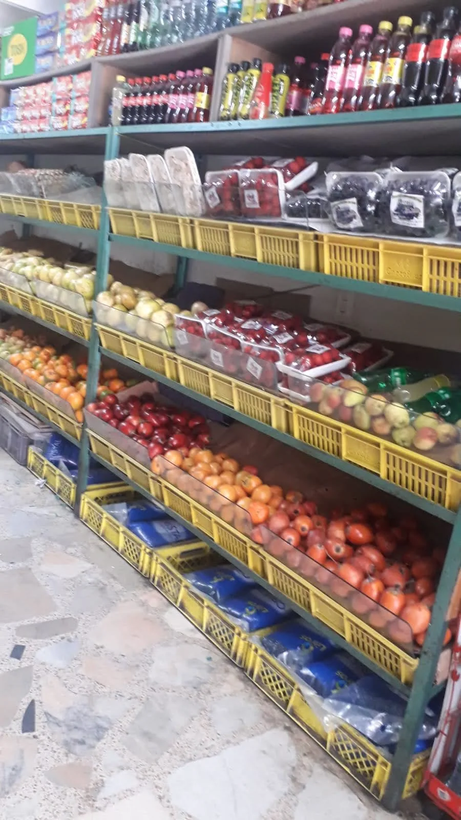 Estantería de frutas y verduras en canastillas dentro de Supermercado Fruver Montes
